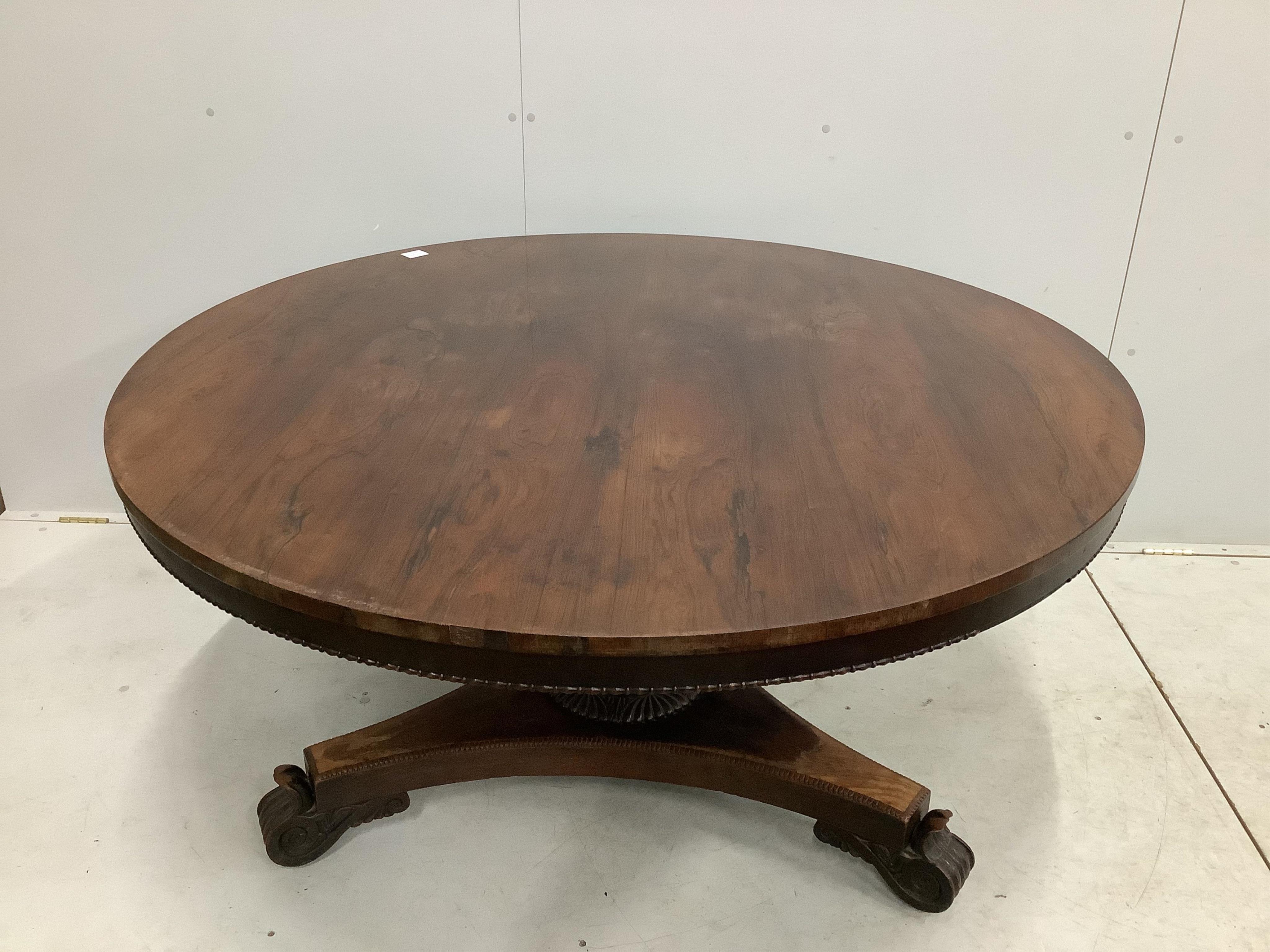 A Victorian rosewood circular tilt top breakfast table, diameter 135cm, height 72cm. Condition - poor to fair, triangular plinth base has lost approximately 10% of veneer